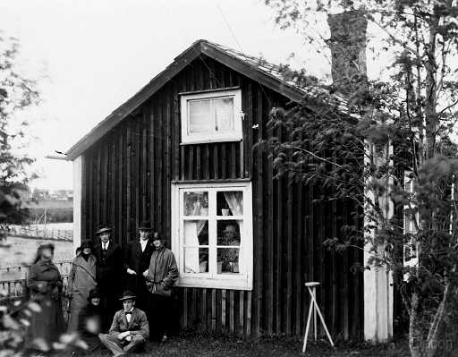 1924 Gruppbild framför hus.jpg - Maria och Erik Ulrik Norbergs hus på Holmen i Råneå (platsen var nuvarande Skärsvägen) fotot taget tidigt 1920 tal. Med på bilden från vänster: Matilda Adolfsson mor till Lisa och Berta med sina äkta hälfter John Victorin och Sigurd Åkre samtliga lärare, sittande Hildur och Knut Sjöberg i fönstret syns Anna Adolfsson.